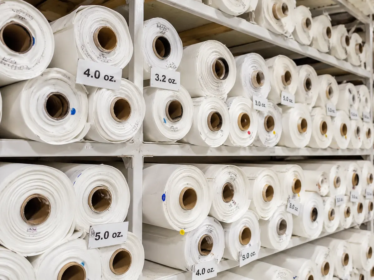 A range of sailcloths in different weights stacked on a shelf