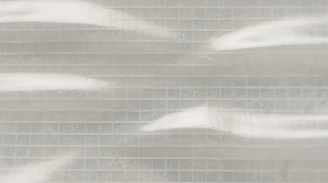 The image shows a close-up detail of semi-transparent laminated sail material
