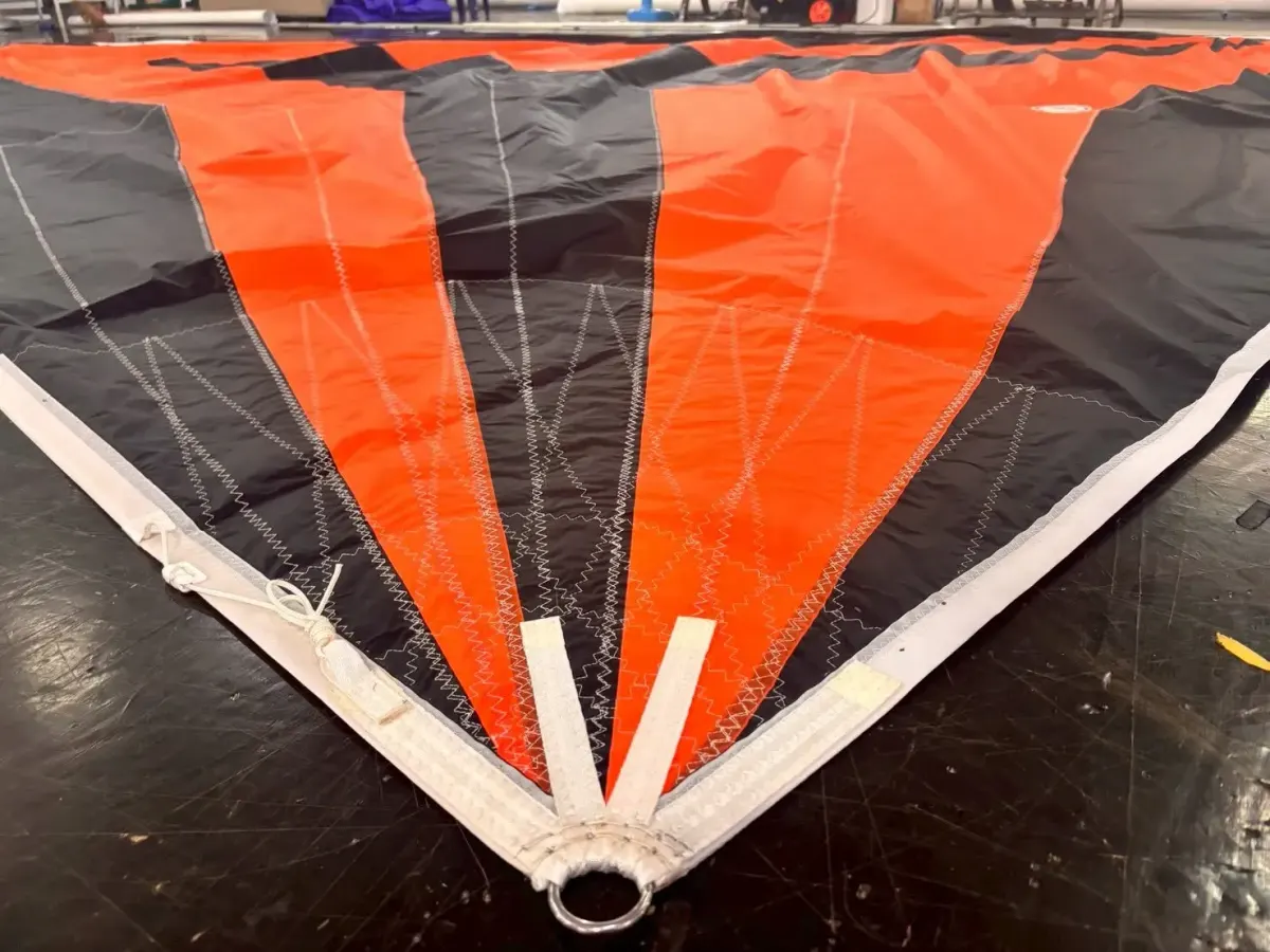 Clew of an orange and black code zero with radial panels converging into a served ring